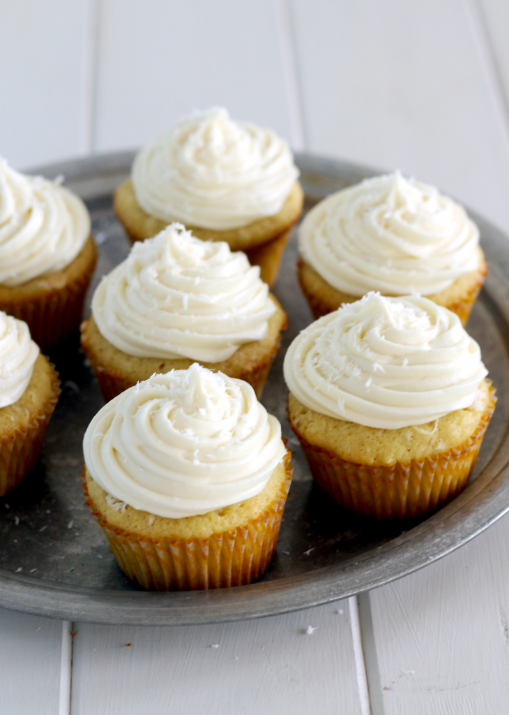 Coconut Cupcakes with White Chocolate Cream Cheese Frosting (and they're stuffed with a truffle!) | Bakerita.com