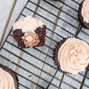 These Chocolate Cupcakes with Nutella Buttercream have a Ferrero Rocher truffle stuffed inside! Everyone will love these surprise inside cupcakes.