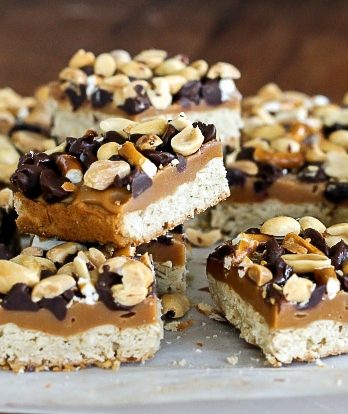These Fully Loaded Bars have an oat shortbread crust topped with peanut butter caramel, pretzels, chocolate chips, and roasted peanuts. They're irresistible!