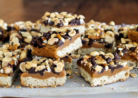 These Fully Loaded Bars have an oat shortbread crust topped with peanut butter caramel, pretzels, chocolate chips, and roasted peanuts. They're irresistible!