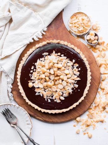 This Dark Chocolate, Coconut & Macadamia Nut Tart is decadent, delicious and easy to make. It has a coconut crust that's filled with a luscious chocolate ganache and topped with toasted coconut and macadamia nuts. You'd never guess that this nutty tart is gluten-free, vegan, Paleo, and refined sugar-free!