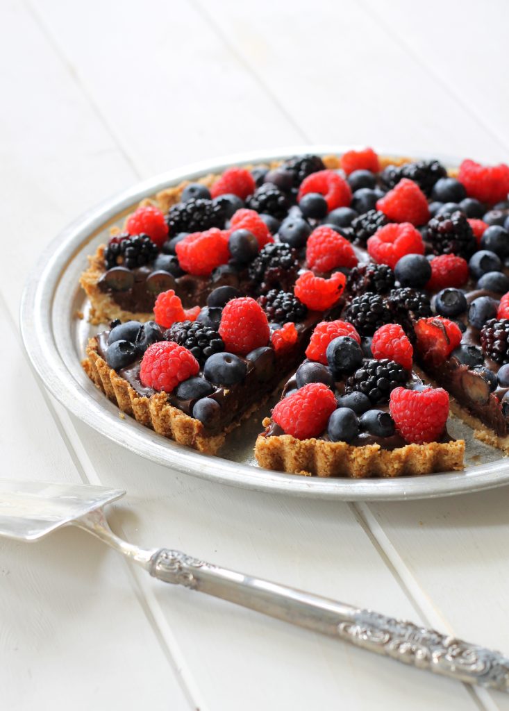 This Chocolate Berry Tart has vegan chocolate ganache in an almond flour crust, topped with fresh berries! This easy, impressive dessert recipe is Paleo, gluten-free, vegan and refined sugar-free.