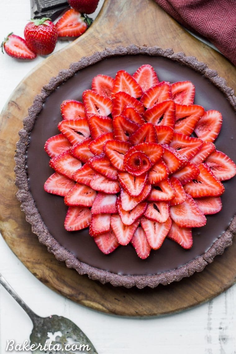 This Strawberry Chocolate Tart is filled with vegan chocolate ganache and topped with fresh strawberries, all in a chocolate crust. Slice into this easy and delicious gluten-free, Paleo, and vegan dessert. #bakerita #strawberrytart #tart #vegan #paleo #glutenfree #chocolate