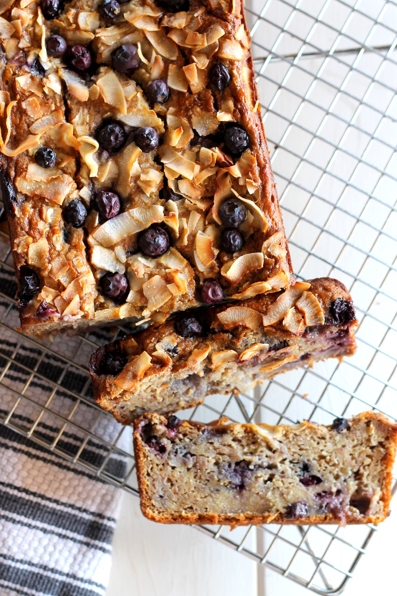 This Toasted Coconut Blueberry Banana Bread boasts delicious flavors - you'd never know that it was low-fat (no butter or oil!), low-sugar, and gluten-free! #bakerita #blueberrybread #bread #blueberries #glutenfree #quickloaf #coconut
