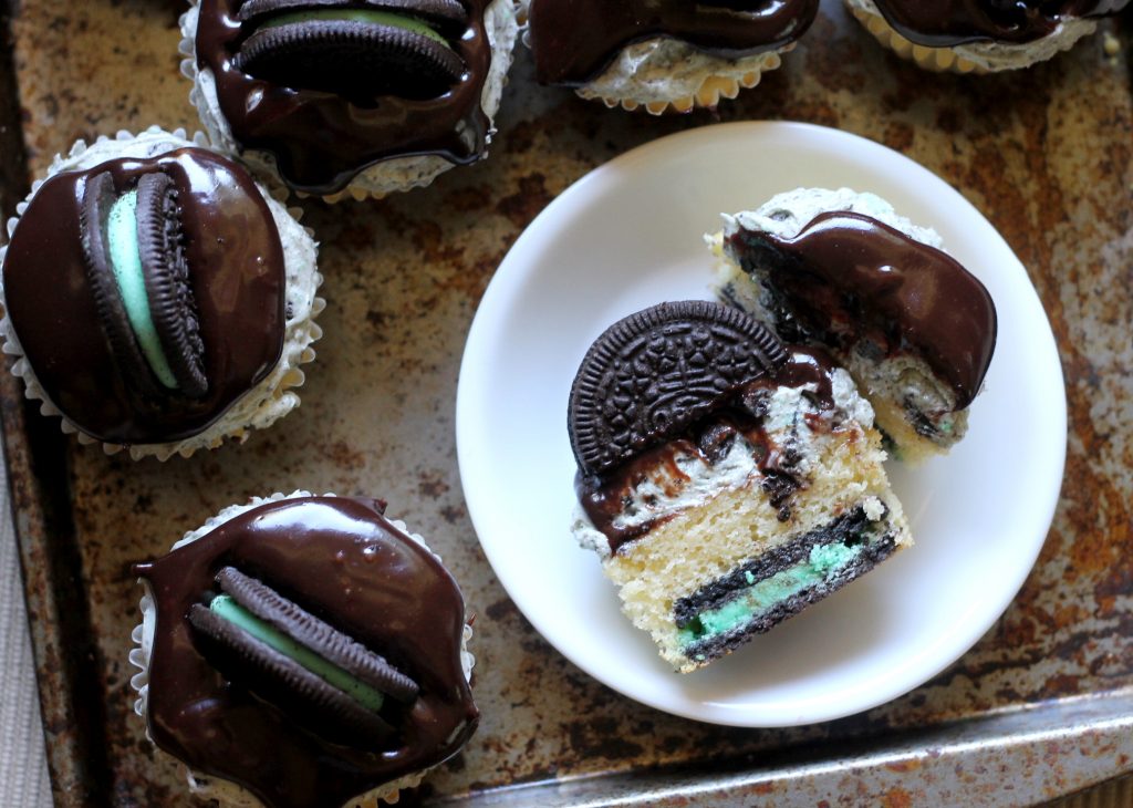 These Mint Cookies & Cream Cupcakes feature a vanilla cupcake with a Mint Oreo at the bottom, Mint Oreo buttercream, & chocolate ganache. You'll love them!