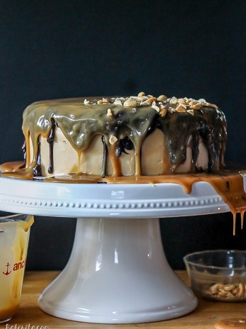 This Ultimate Snickers Cake is six-layers of chocolate cake with peanut caramel filling and peanut butter cream cheese frosting, dripping with chocolate ganache and caramel sauce. It tastes just like a Snickers bar!
