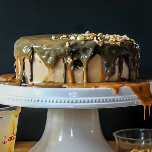 This Ultimate Snickers Cake is six-layers of chocolate cake with peanut caramel filling and peanut butter cream cheese frosting, dripping with chocolate ganache and caramel sauce. It tastes just like a Snickers bar!