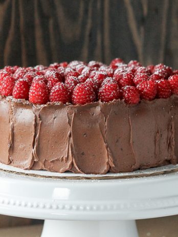 This Mocha Raspberry Cake has two layers of moist chocolate cake, a layer of sweet raspberry filling, frosted with a silky mocha buttercream and topped with fresh raspberries! This impressive cake is perfect for celebrating.