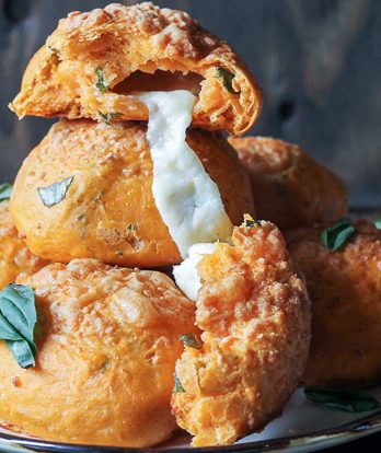 These Cheesy Tomato Basil Rolls are packed full of tomato flavor and fresh basil with gooey mozzarella cheese melting out of the middle and a Parmesan crust on top! These are the perfect snack or soup accompaniment.