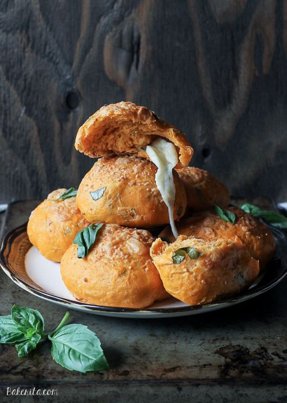 These Cheesy Tomato Basil Rolls are packed full of tomato flavor and fresh basil with gooey mozzarella cheese melting out of the middle and a Parmesan crust on top! These are the perfect snack or soup accompaniment.