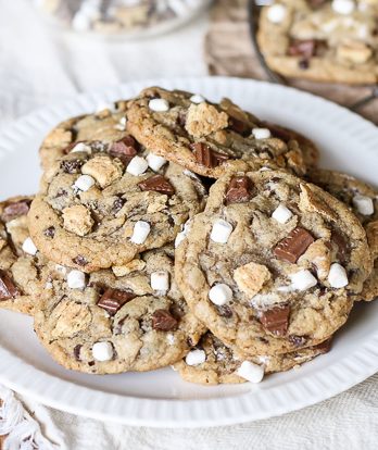 Skip the campfire and whip up a batch of S'mores Cookies! Made with graham cracker cookie dough, chocolate chips & marshmallow bits, these s'mores cookies taste just like your favorite summer treat so you can have s'mores year round.