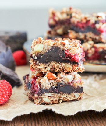 These Raspberry Chocolate Chunk Bars have a crust that doubles as a crumble topping and are loaded with raspberries, dark chocolate, and almonds. This easy recipe is gluten free, refined sugar free, and vegan!