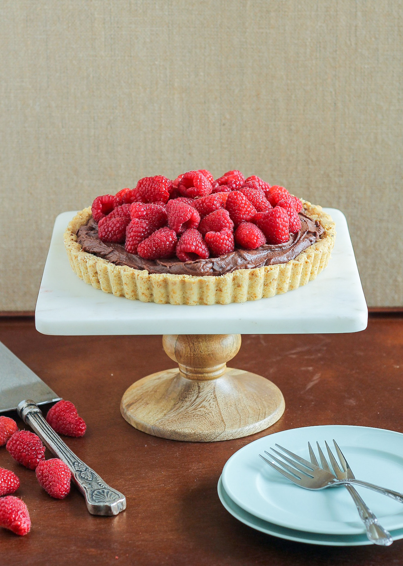 This Whipped Chocolate Ganache Raspberry Tart has an almond flour crust filled with creamy chocolate ganache topped with fresh raspberries! It's naturally gluten free.