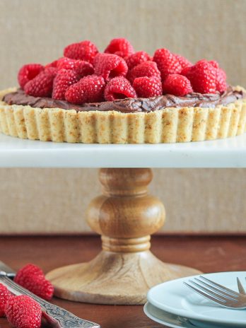 This Whipped Chocolate Ganache Raspberry Tart has an almond flour crust filled with creamy chocolate ganache topped with fresh raspberries! It's naturally gluten free.