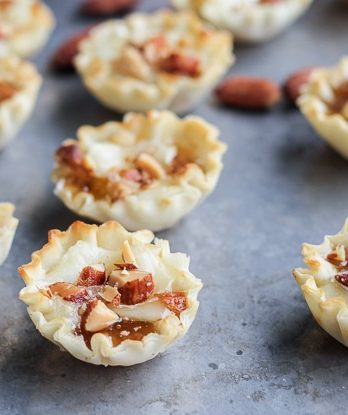 These Easy Brie Bites have only four ingredients, but make a delicious appetizer that you won't be able to get enough of! Gooey brie and crunchy smokehouse almonds make this simple appetizer recipe shine.