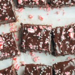 These Peppermint Brownies are classic fudge brownies with peppermint extract and mint chips for a chilly winter twist. This easy brownie recipe is topped with dark chocolate ganache and crushed candy canes.
