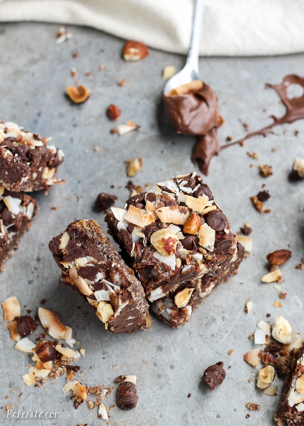 These Chocolate Hazelnut Magic Bars are a new flavor twist on a classic cookie bar. The crust is kept naturally gluten-free with hazelnut flour. A gooey Nutella filling and topping made of chocolate chips, flaked coconut, and hazelnuts takes these bars over the top!