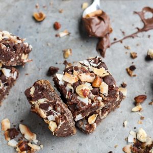 These Chocolate Hazelnut Magic Bars are a new flavor twist on a classic cookie bar. The crust is kept naturally gluten-free with hazelnut flour. A gooey Nutella filling and topping made of chocolate chips, flaked coconut, and hazelnuts takes these bars over the top!