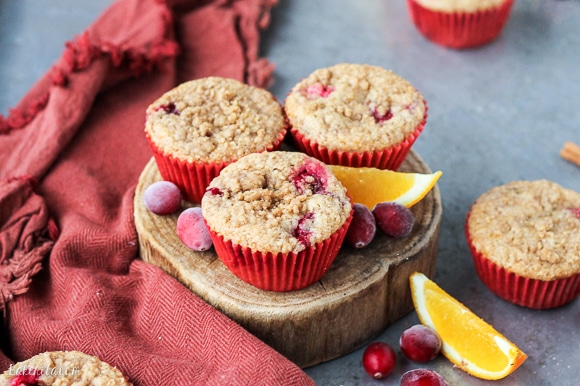These Cranberry Orange Muffins are bursting with tart cranberries + orange zest and topped with a sweet crumble - you'd never guess that they're vegan!