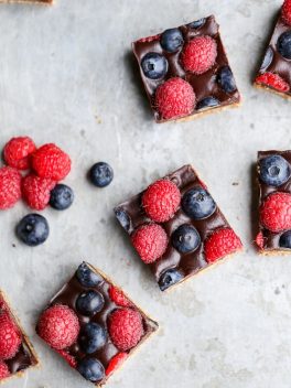 These Chocolate Berry Bars have an almond flour crust topped with vegan chocolate ganache and fresh raspberries and blueberries. These dessert bars are beautiful, delicious, and better for you - they're gluten-free, vegan, refined sugar-free, and Paleo.