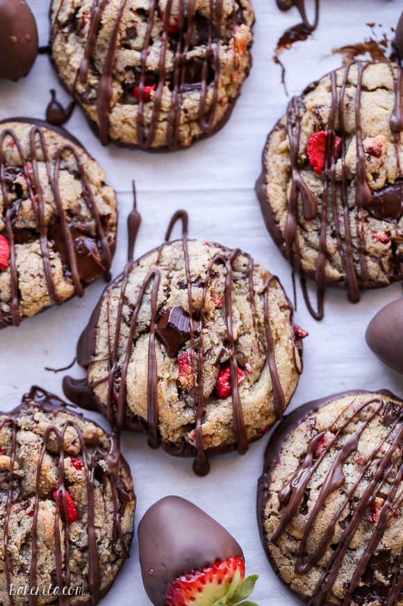These Chocolate-Dipped Strawberry Chocolate Chip Cookies are soft + chewy cookies full of freeze dried strawberries and chocolate chunks, dipped and drizzled with dark chocolate.