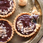 These Chocolate Ganache Tarts with Coconut Macaroon Crust are Paleo, gluten-free + refined sugar free, but you'd never guess from the decadent vegan chocolate ganache or sweet and chewy crust.