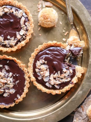 These Chocolate Ganache Tarts with Coconut Macaroon Crust are Paleo, gluten-free + refined sugar free, but you'd never guess from the decadent vegan chocolate ganache or sweet and chewy crust.