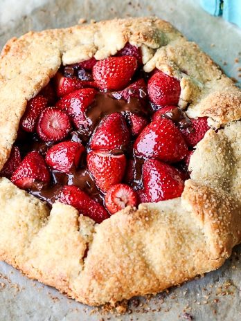 This rustic Chocolate Strawberry Galette will satisfy your sweet tooth guiltlessly! This simple Paleo dessert features fresh strawberries and dark chocolate chunks, folded into a flaky gluten-free crust.