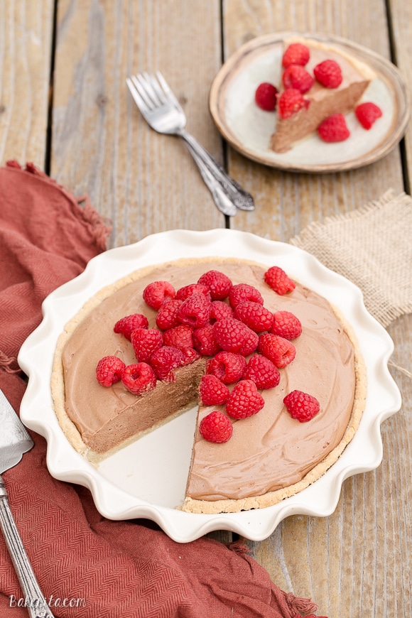 This Paleo Fresh Raspberry French Silk Pie has an almond flour crust filled with a super creamy chocolate pie filling. Fresh raspberries add brightness to this rich dessert.
