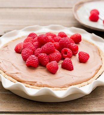 This Paleo Fresh Raspberry French Silk Pie has an almond flour crust filled with a super creamy chocolate pie filling. Fresh raspberries add brightness to this rich dessert.