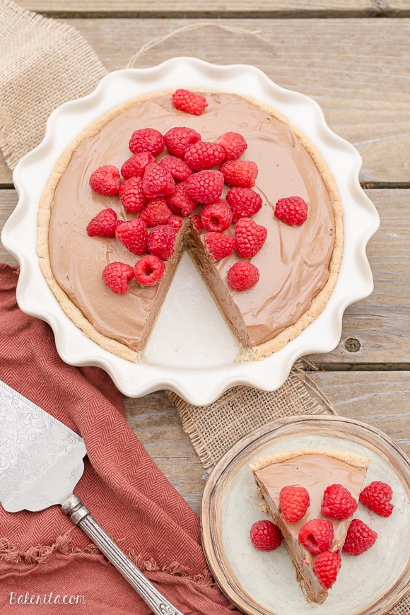 This Paleo Fresh Raspberry French Silk Pie has an almond flour crust filled with a super creamy chocolate pie filling. Fresh raspberries add brightness to this rich dessert.
