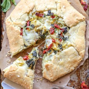This Spinach + Artichoke Mediterranean Galette has sun-dried tomatoes, artichoke hearts, feta cheese, and gooey mozzarella tucked into a flaky gluten-free and grain-free crust. Pair with a side salad for the perfect lunch or dinner.