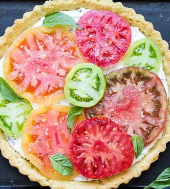 This Ricotta Heirloom Tomato Tart has a gluten-free cornmeal crust and basil ricotta filling, topped with beautiful heirloom tomatoes! This simple tart makes a wonder appetizer, lunch, or dinner.