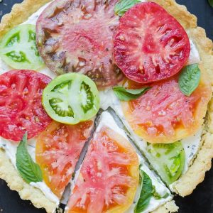 This Ricotta Heirloom Tomato Tart has a gluten-free cornmeal crust and basil ricotta filling, topped with beautiful heirloom tomatoes! This simple tart makes a wonder appetizer, lunch, or dinner.