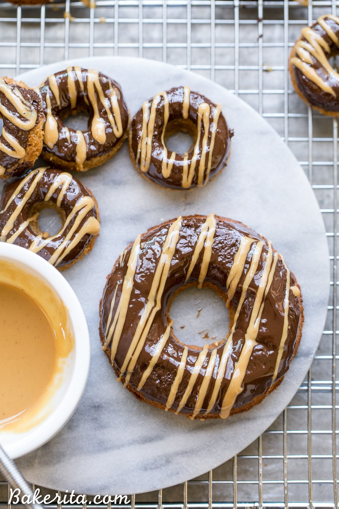 These Peanut Butter Banana Donuts have a dark chocolate glaze topped with a drizzle of peanut butter! They're baked instead of fried, and they are gluten-free, refined sugar-free, and vegan, making them way healthier than your average donut.