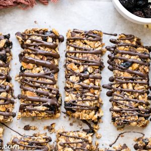 These no bake Dried Cherry, Almond + Chocolate Chip Granola Bars are the perfect grab and go breakfast or snack. These flavor-packed granola bars are gluten free, refined sugar free, vegan, and topped with a dark chocolate drizzle!