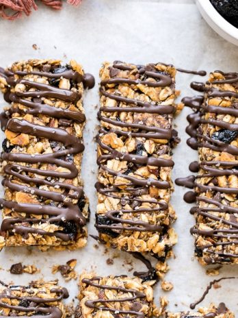 These no bake Dried Cherry, Almond + Chocolate Chip Granola Bars are the perfect grab and go breakfast or snack. These flavor-packed granola bars are gluten free, refined sugar free, vegan, and topped with a dark chocolate drizzle!