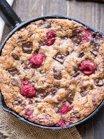 This Raspberry Chocolate Chunk Skillet Cookie is an easy, one bowl recipe loaded with fresh raspberries and dark chocolate chunks. This gooey skillet cookie is gluten-free, Paleo, and refined sugar free.