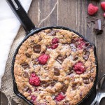 This Raspberry Chocolate Chunk Skillet Cookie is an easy, one bowl recipe loaded with fresh raspberries and dark chocolate chunks. This gooey skillet cookie is gluten-free, Paleo, and refined sugar free.