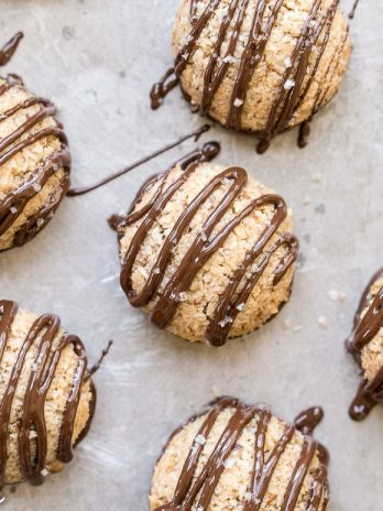 These Chocolate-Dipped Vanilla Bean Macaroons are a quick and easy dessert that is gluten-free, Paleo + vegan! These macaroons are baked low and slow and have a chocolate drizzle.