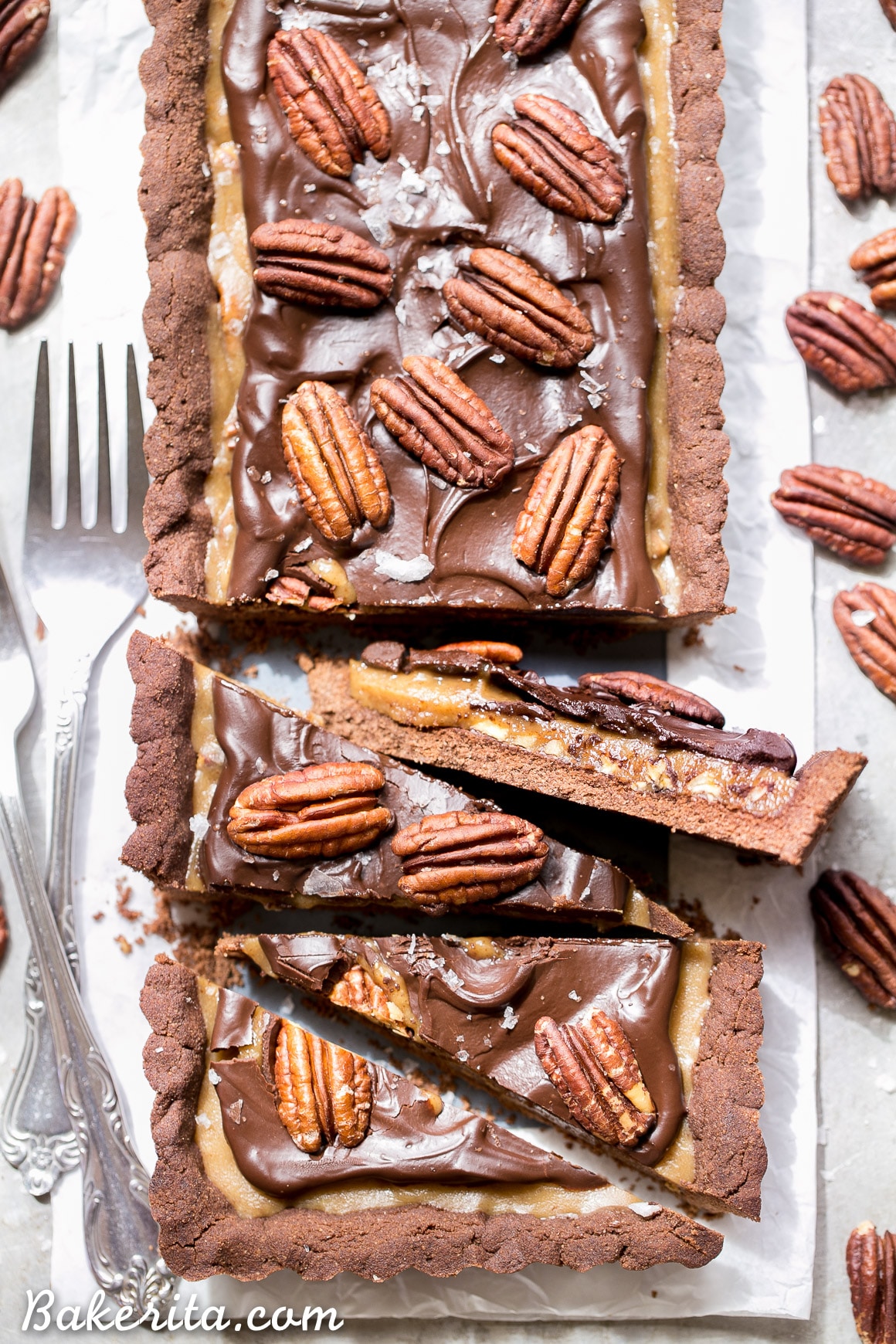 This Chocolate Pecan Tart has a chocolate shortbread crust, pecan pie filling, and is topped with dark chocolate ganache, pecans + a sprinkle of sea salt! You won't believe that this is gluten-free, Paleo, refined sugar free, and vegan.