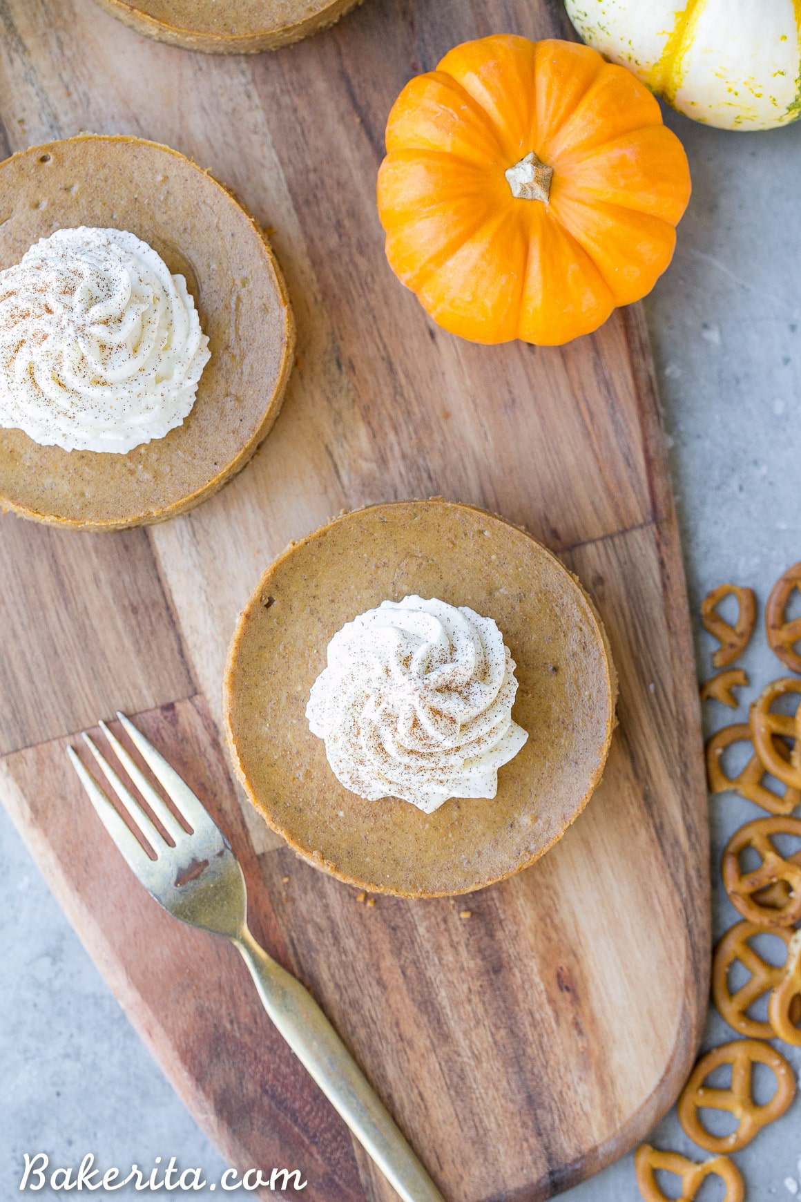 These Mini Pumpkin Cheesecakes have a crunchy, salty pretzel crust that pairs irresistibly well with the spiced pumpkin cheesecake filling! Topped with a swirl of whipped cream, this is a gluten-free dessert everyone will go nuts for - it's perfect for the holidays.