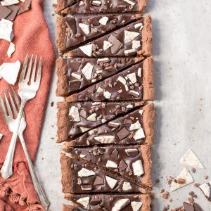 This Gluten-Free Peppermint Mocha Tart has a chocolate shortbread crust filled with a luscious peppermint mocha chocolate ganache! This quick + easy dessert is perfect for the holidays.