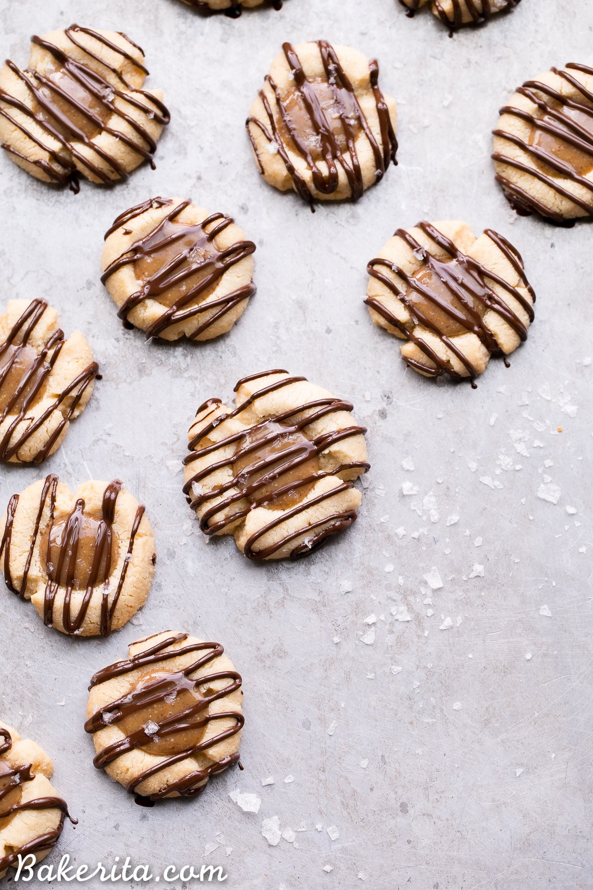 These Salted Caramel Thumbprint Cookies are super easy to make with only 6 ingredients total! The tender gluten-free and Paleo shortbread cookies are filled with a no-cook vegan caramel and topped off with a dark chocolate drizzle and flaky sea salt. They're perfect for the holidays!