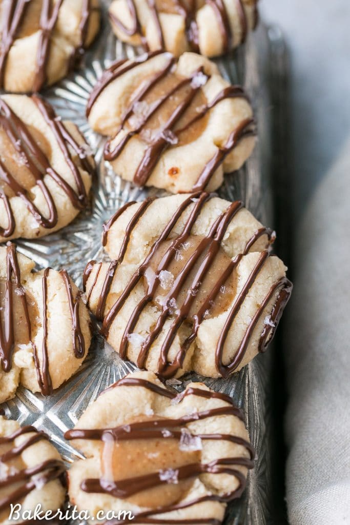 These Salted Caramel Thumbprint Cookies are super easy to make with only 6 ingredients total! The tender gluten-free and Paleo shortbread cookies are filled with a no-cook vegan caramel and topped off with a dark chocolate drizzle and flaky sea salt. They're perfect for the holidays!