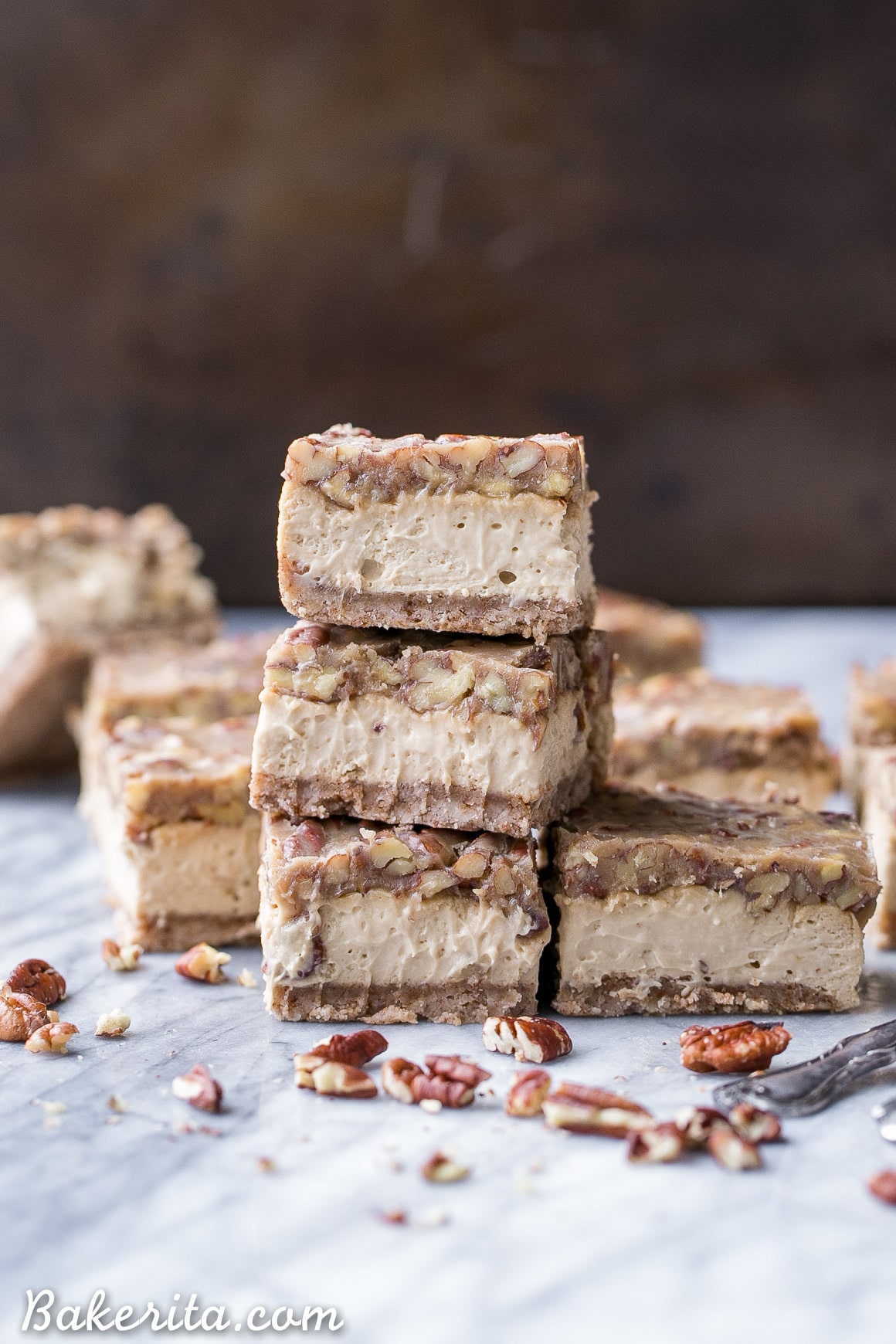 These Gluten Free Pecan Praline Cheesecake Bars will be your new favorite dessert! The super creamy cheesecake filling has a sweet + crunchy pecan praline topping.