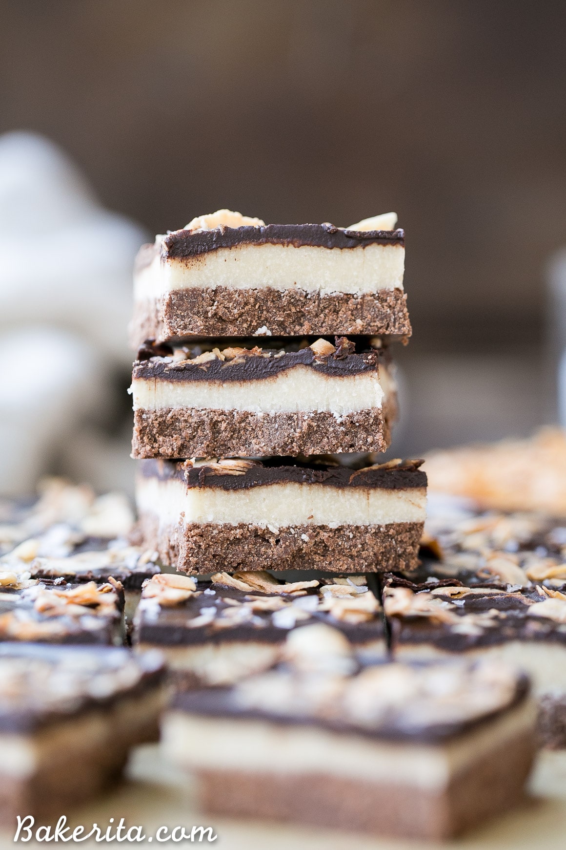 These Chocolate Coconut Bars have three irresistible layers - a chocolate shortbread crust, a melt-in-your-mouth coconut butter filling, and a chocolate topping with toasted coconut! Any coconut lover is going to love these gluten-free, Paleo + vegan dessert bars.
