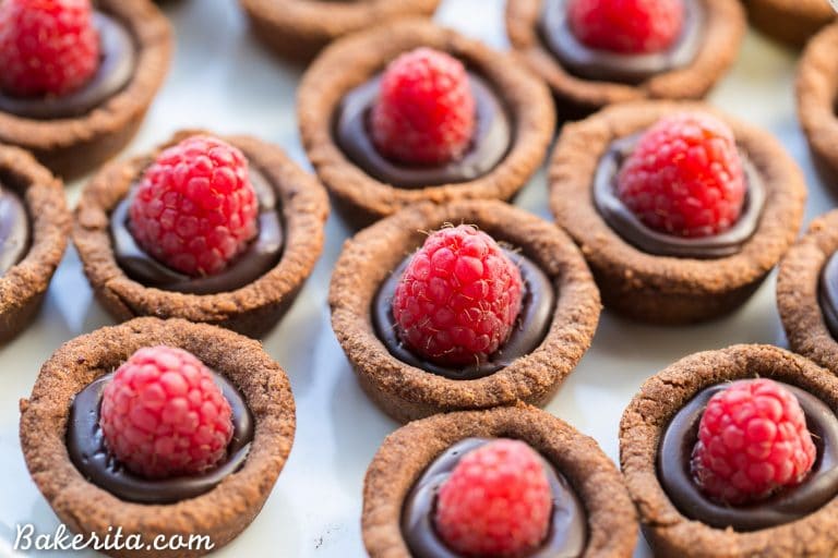 These Chocolate Raspberry Tartlets are super chocolatey bites - they have a chocolate shortbread crust filled with chocolate ganache and topped with a fresh raspberry. Satisfy your chocolate craving with one of these gluten-free, Paleo + vegan tartlets.