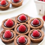 These Chocolate Raspberry Tartlets are super chocolatey bites - they have a chocolate shortbread crust filled with chocolate ganache and topped with a fresh raspberry. Satisfy your chocolate craving with one of these gluten-free, Paleo + vegan tartlets.