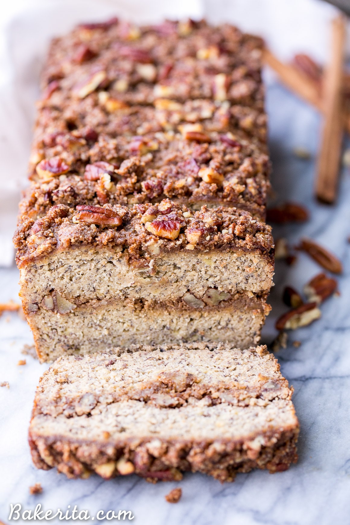 This Paleo Cinnamon Streusel Banana Bread has a layer of pecan crumble in the center and on top, creating a ripple of cinnamon flavor throughout the whole loaf of banana bread. This moist gluten-free + refined sugar free bread is sweetened with bananas and made with coconut flour.